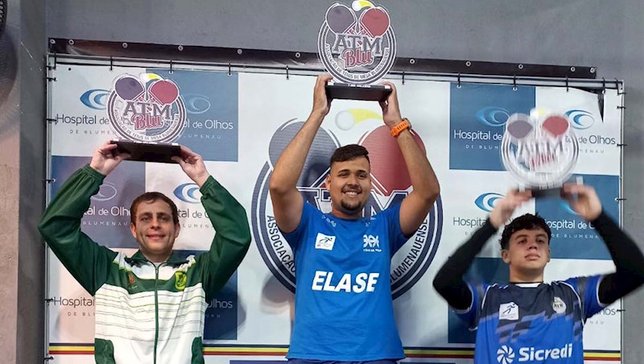 Técnico e atleta Túlio Moreira (E) com o troféu | 